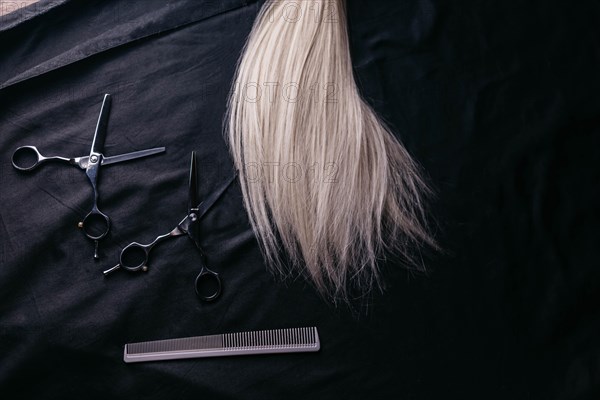 Natural hair of different colors with scissors and comb. concept of hair care and hairdressing services
