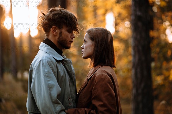 Romantic couple of lovers on a date in the park in cold weather. Fashionable couple in coat