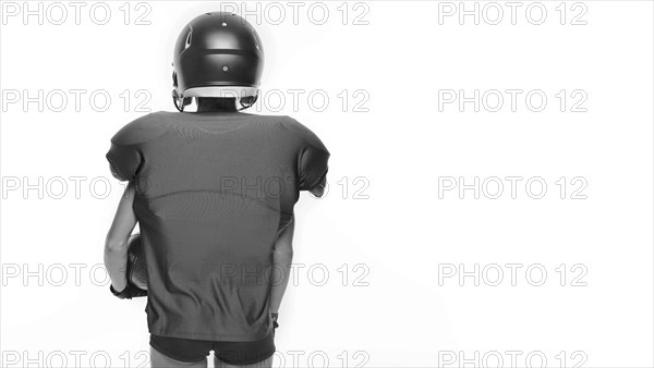 Black and white images of a sports girl in the uniform of an American football team player. Sports concept. White background.