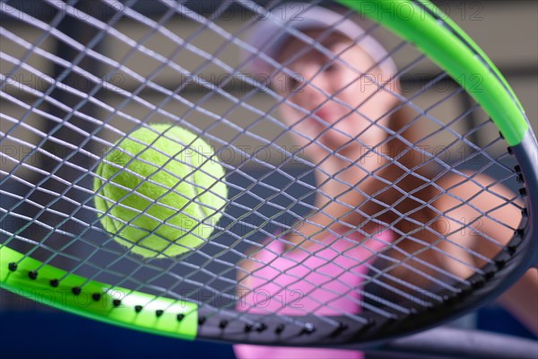 Image of a tennis ball on the background of the strings of the racket. Sports concept.
