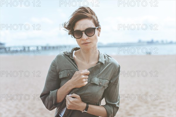 Image of a beautiful woman on the beach of the Gulf of Finland in St. Petersburg. Windy weather. Happiness