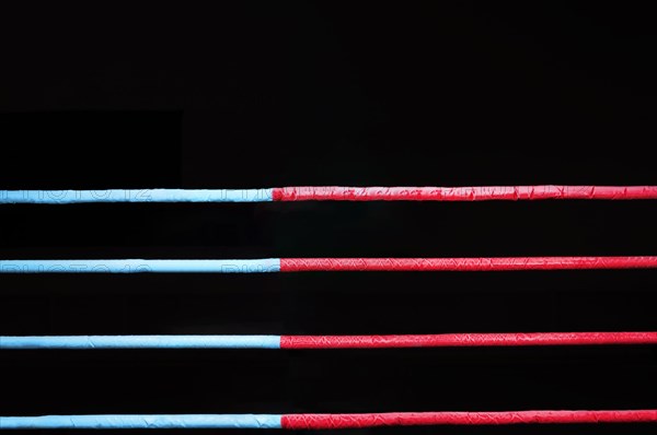 Boxing ring ropes on a black background. The concept of sports