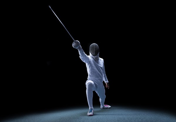 The fencer moves forward with a sword in his hand. Sport concept.