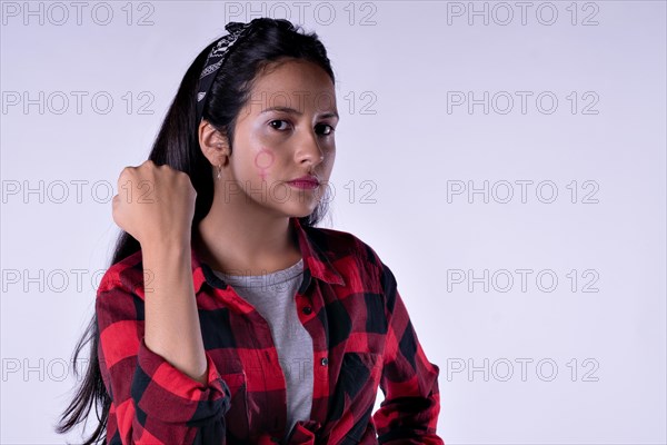 Long haired girl showing painting symbol on face isolated on lilac pastel background. Concept WomenÂ´s day. Copy space. Portrait in studio