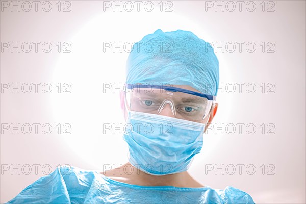 Male surgeon doctor in the operating room looking at the patient at the camera