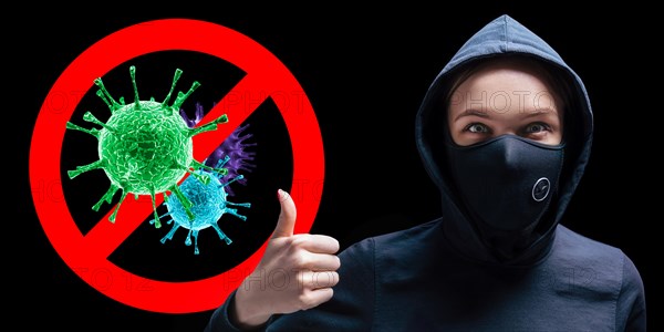 Portrait of a girl in a protective mask who shows up her finger against the background of the stop viruses sign.