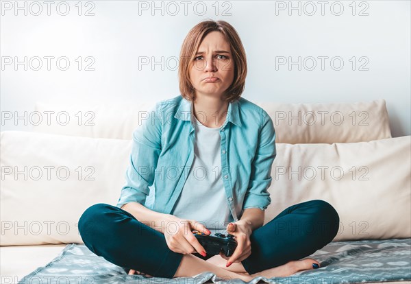 Girl with a joystick in her hands cries because of a defeat in the game. ESports concept.