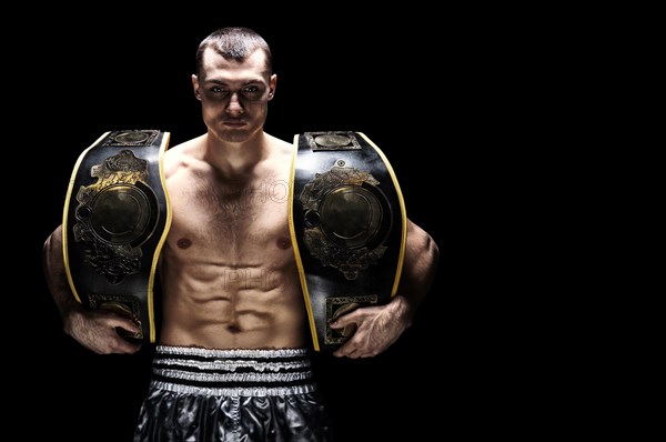 Kickboxing world middleweight champion stands with two belts. The concept of a healthy lifestyle