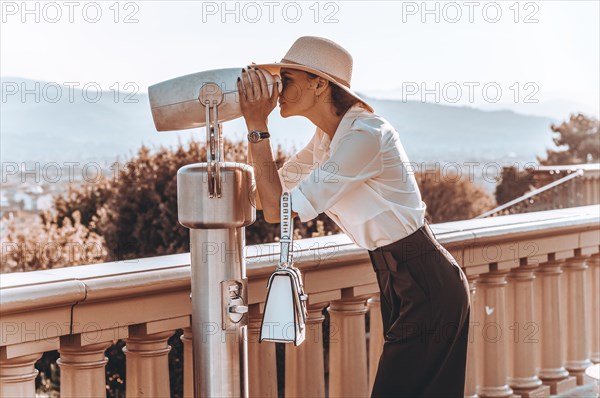 Girl looks at the panorama of Florence through a binoscope. The concept of tourism