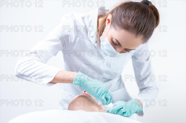 The beautician washes the patient's face before peeling. Skin care concept.