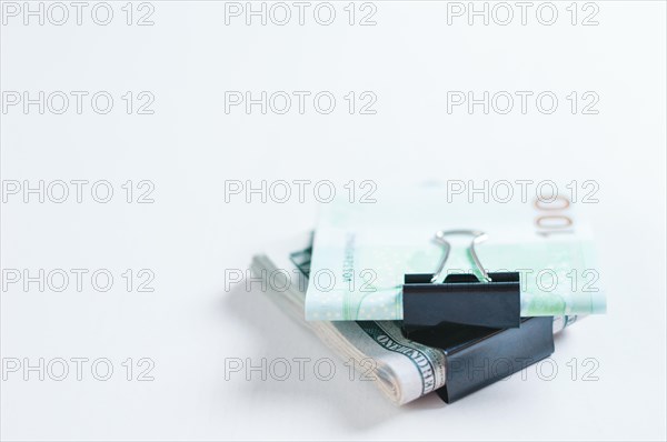 Packs of euros and hundred-dollar bills lie on a white table fastened with paperclips. The concept of savings during the crisis. Dollars vs Euros.