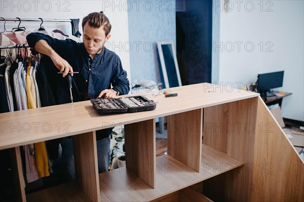 Young handsome carpenter assembling a wardrobe at a customer's home