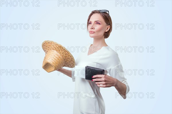 Beautiful girl posing on a white background in a yellow hat with a passport and boarding pass. Tourism concept.
