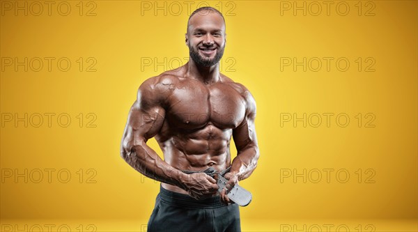 Isolated professional sportsman on a yellow background. Bodybuilding concept. Panorama. Advertising of a gym and sports nutrition.