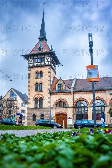 Street view of a city with a tower and a bus station on a cloudy day