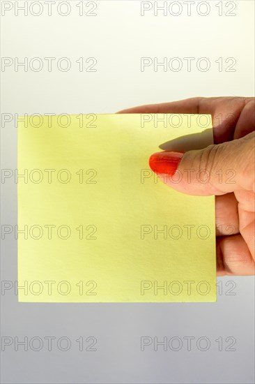 Woman's hand with painted nails holding blank letter paper on pure white background