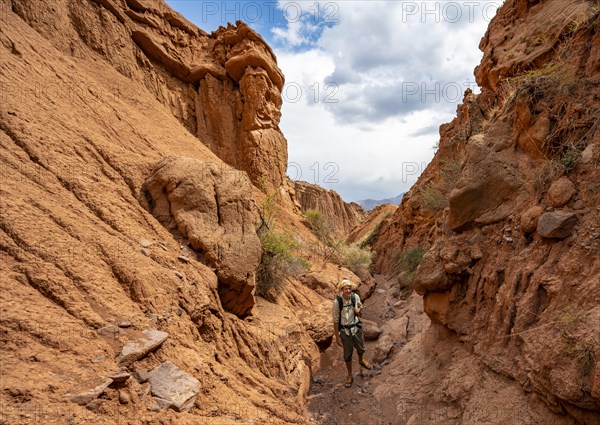 Mountaineer in a canyon with a dry stream bed