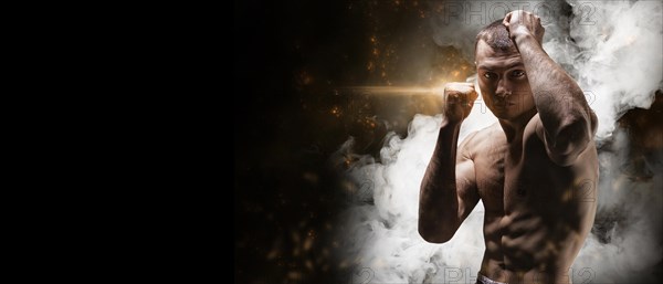 Professional boxer posing in the studio. He stands in front of the camera and elbows. The concept of sport