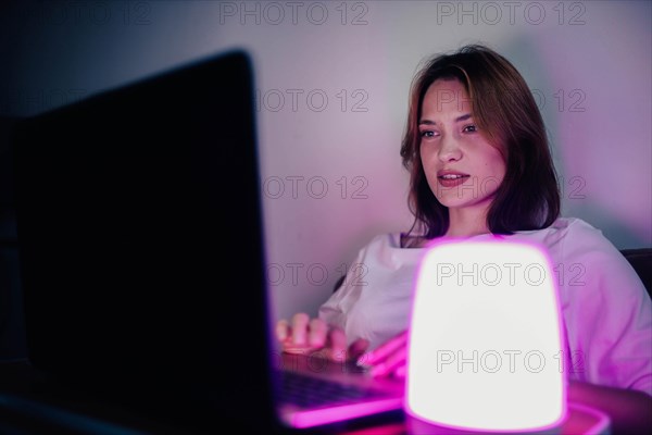 A young pretty girl works at home on a laptop