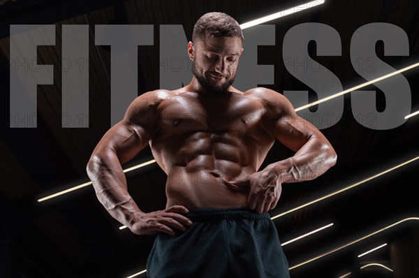 Portrait of an athletic muscular man who checks the condition of the abdominal muscles. Fitness concept