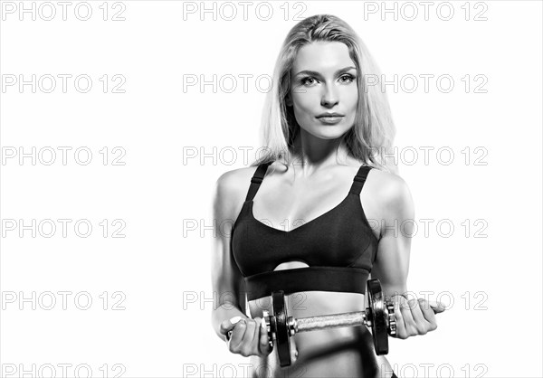 Charming athlete bends arm with dumbbell.