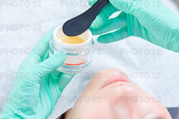 Image of a jar with a yellow mask for skin care. Concept for beauty salons.