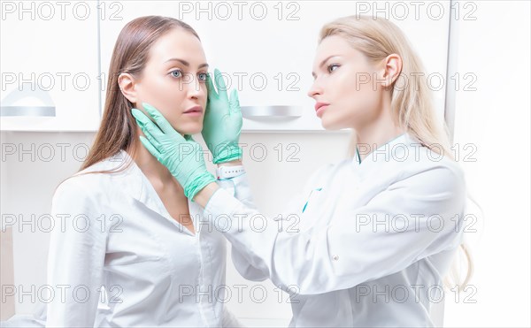 Beautiful girl at a consultation in the salon with a plastic surgeon. Beauty industry concept.