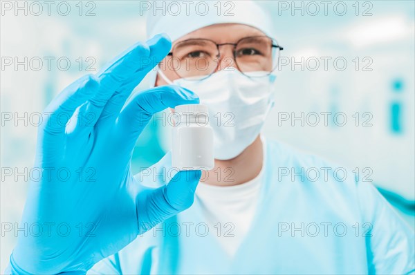 Portrait of a doctor with a jar of pill in hand. Private clinic. Medicine concept.