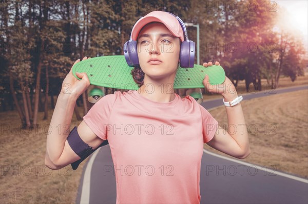 Portrait of a teenage girl with a skateboard. Sports lifestyle concept.