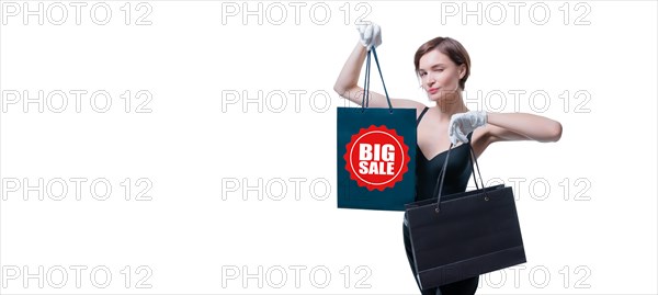Stylish tall girl in white gloves demonstrates a black luxury package. The concept of safe shopping during a pandemic