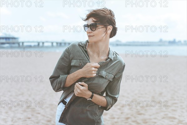 Image of a beautiful woman on the beach of the Gulf of Finland in St. Petersburg. Windy weather. Happiness