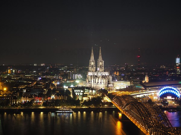 Aerial night view of St Peter Cathedral and Hohenzollern Bridge over river Rhine in Cologne