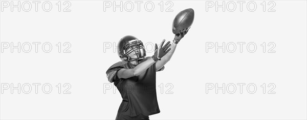 Black and white images of a sports girl in the uniform of an American football team player. Sports concept. White background.