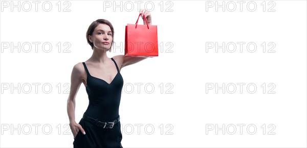 Portrait of stylish adult woman posing in studio on white background with red gift bag. Valentine's Day concept. Holidays and gifts