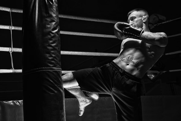 Kickboxer hits the bag with his knee. Training a professional athlete. The concept of mma