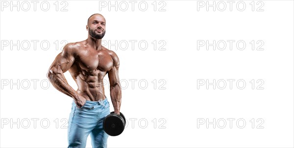 Sportsman posing on a white background in jeans with a dumbbell in his hand. Fitness
