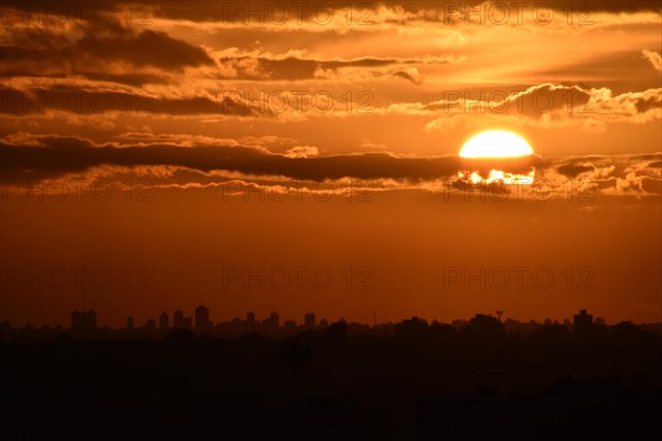 Sun and clouds with skyline of Buenos Aires at sunset