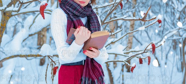 No name oil portrait of a charming girl reading a book in a winter forest. Concept of Christmas