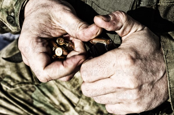 The fighter prepares a clip with bullets before the next fight.