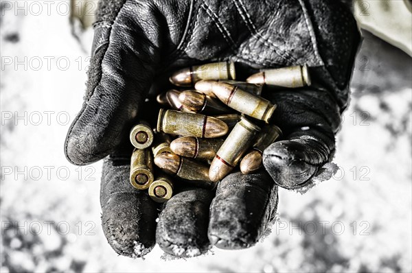 The fighter holds a handful of bullets in his palm for weapons.