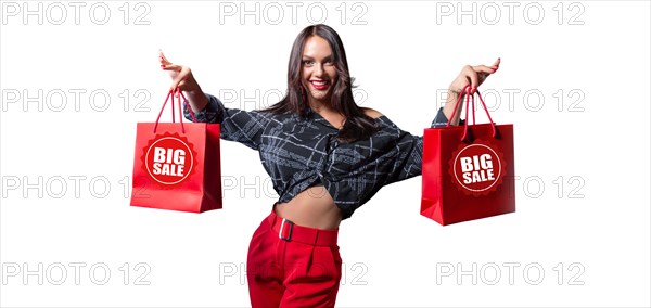 Beautiful happy brunette with red packages in her hands. White background. Concept for discounts