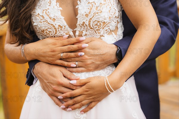 Hands of bride and groom embraced with rings at a beautiful wedding