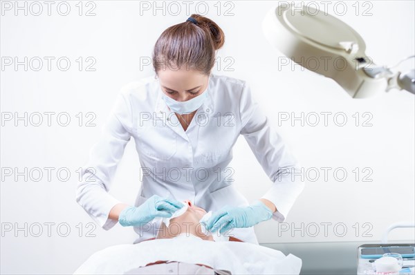 The beautician washes the patient's face before peeling. Skin care concept.