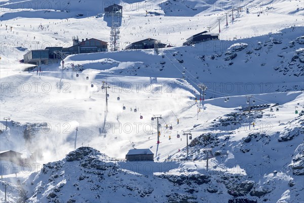 Snow-covered ski resort with active ski lifts in a mountainous alpine region