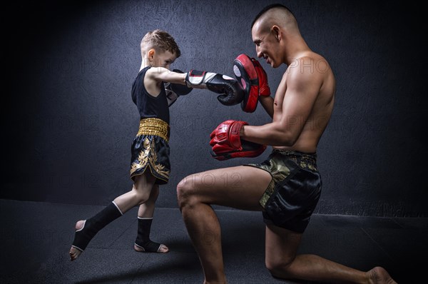 Kickboxing coach is training the boy. The concept of family