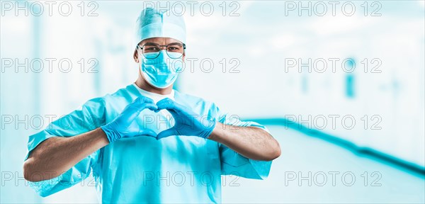 Portrait of a doctor in a hospital. He folded his hands in the shape of a heart. Medicine concept.