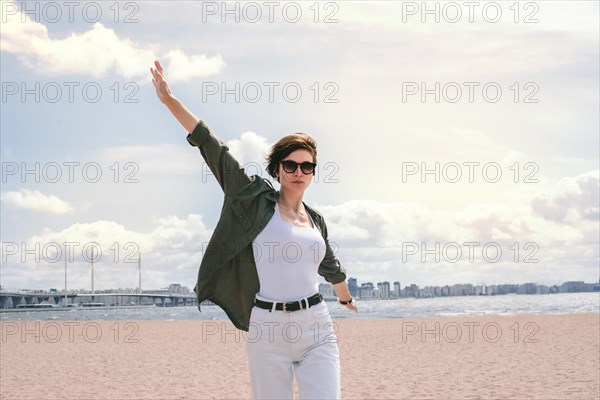 Image of a beautiful woman on the beach of the Gulf of Finland in St. Petersburg. Windy weather. Happiness