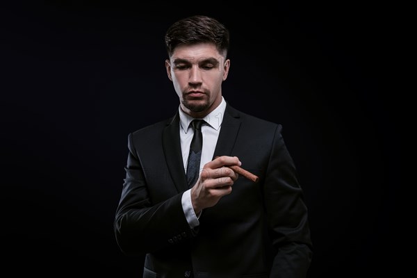 Portrait of a stylish man in a suit with a cigar. Business concept.