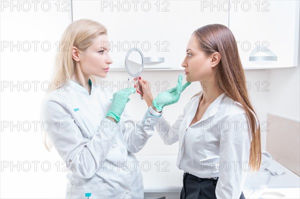 Portrait of the beautician and patient. The doctor injects botox. Skin rejuvenation and lifting concept.