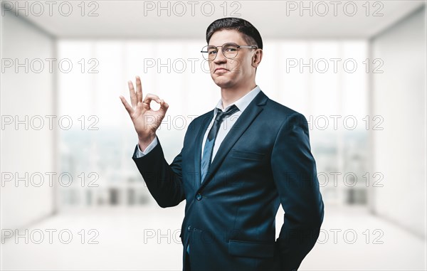 Real estate agent stands in a bright office and shows the ok sign to the camera. The concept of the sale of real estate